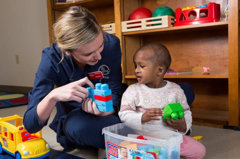 Graduate student clinician engaging performing therapy in the Speech and Hearing Clinic. 